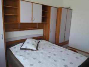 niewielka sypialnia z łóżkiem i szafkami w obiekcie Apartament Selimbar w Sybinie