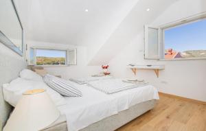 a white bedroom with a bed and a window at Apartments Marivo in Mlini