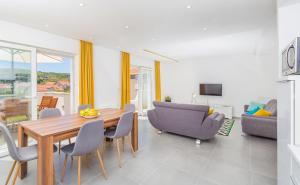 a dining room with a table and chairs and a couch at Apartments Marivo in Mlini