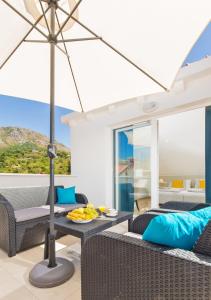 a patio with chairs and tables with an umbrella at Apartments Marivo in Mlini