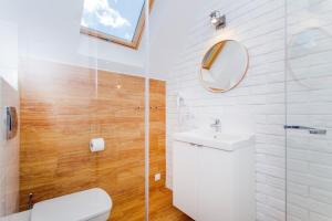 a bathroom with a toilet and a sink and a mirror at Apartamenty Bałtyckie in Lubiatowo