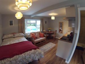 チェルトナムにあるCheltenham Studio Apartmentのベッドルーム1室(ベッド1台付)、リビングルームが備わります。