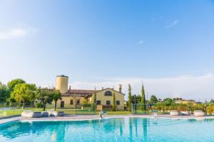 a swimming pool with a house in the background at La Posa degli Agri in Legnaro