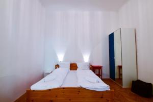 ブダペストにあるChess table - Lovely home on the shopping streetの白い壁の木製ベッド1台が備わるベッドルーム1室が備わります。