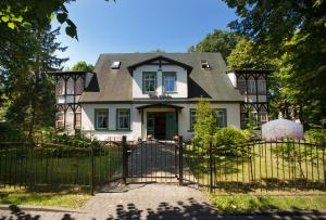 a house with a gate in front of it at Wille Amber in Mielno
