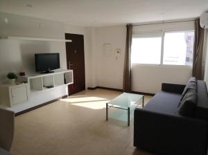 sala de estar con sofá y TV en Apartamento Comedias, en Málaga