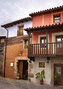 a house with a balcony on the side of it at Apartamentos Rurales Los Vergeles in Valverde de la Vera
