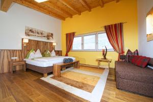 pokój hotelowy z łóżkiem i kanapą w obiekcie Greenhome Appartement w mieście Niedernsill
