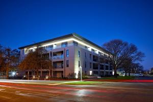 ein großes weißes Gebäude mit Lichtern vor einer Straße in der Unterkunft Knightsbridge Canberra in Canberra