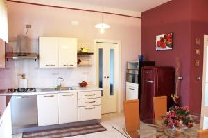 kuchnia z białymi szafkami i czerwoną lodówką w obiekcie Eleatica Holiday Apartment w mieście Ascea +35 zdjęć