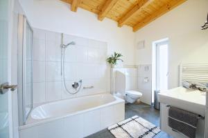 biała łazienka z wanną i toaletą w obiekcie Greenhome Appartement w mieście Niedernsill +19 zdjęć