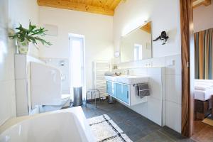 łazienka z wanną, umywalką i toaletą w obiekcie Greenhome Appartement w mieście Niedernsill