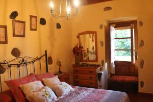 sypialnia z łóżkiem, komodą i lustrem w obiekcie Casa Rural Las Rosas w mieście Agulo