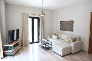 uma sala de estar com um sofá branco e uma televisão em Sleepin Sevilla Arenal em Sevilha