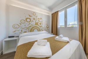 ein Schlafzimmer mit einem Bett mit Handtüchern darauf in der Unterkunft Hotel Triton Beach in Cala Ratjada