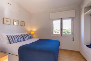 Casa do Largo في كاسكايس: غرفة نوم بسرير ازرق وبيض ونافذة