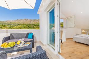 a living room with a table and chairs and a bed at Apartments Marivo in Mlini