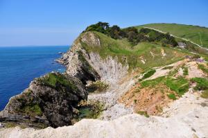 a rocky hillside next to the ocean at Lulworth Cove Inn in Lulworth Cove