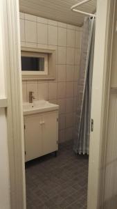 a bathroom with a sink and a shower curtain at Vehmaanpirtti in Orivesi