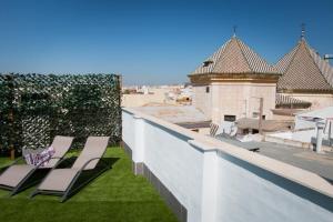 uma fila de cadeiras no telhado de um edifício em Holidays2Malaga Suites em Málaga
