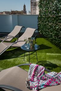 una mesa con gafas y un tazón sobre hierba en Holidays2Malaga Suites, en Málaga