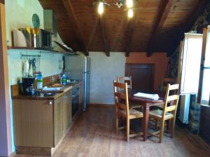 a kitchen with a table and a table and chairs at Apartamentos Rurales Casa Cachon in Santa Eulalia de Cueras