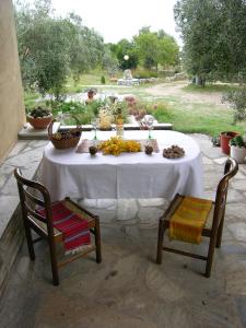 a table with a white table cloth and two chairs at Kyra's Paradise in Potistika