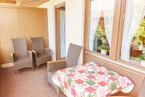 eine Veranda mit einem Tisch, Stühlen und einem Fenster in der Unterkunft Ferienwohnung Decker in Oberstdorf