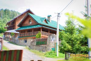Casa de madera grande con techo verde en Podolyanka, en Slavske