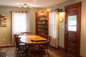 a dining room with a wooden table and chairs at Profile Motel & Cottages in Lincoln