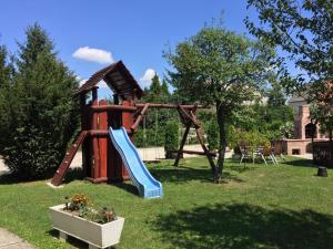 um parque infantil com um escorrega num quintal em Tóth Vendégház em Bük