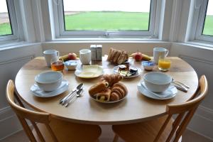 una mesa de madera con productos para el desayuno en Burnside Farm B & B, en Girvan