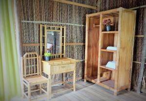 een kamer met een bureau, een spiegel en een plank bij Green Village Mekong in Can Tho