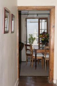 a dining room with a table and chairs and a mirror at De Kothuize 16 in Graaff-Reinet