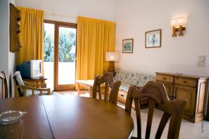 a living room with a table and chairs and a couch at Apartamentos Leo in Port de Pollensa