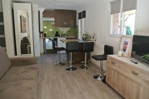 a living room with a couch and a tv and a kitchen at Les rives de St Tropez in Saint-Tropez