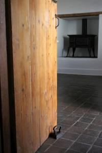 a wooden door in a room with a table at De Kothuize 16 in Graaff-Reinet
