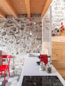 cocina con fregadero blanco y silla roja en La Casa Della Zia, en Sarnico