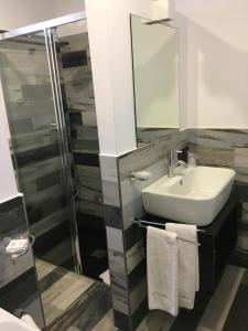 a bathroom with a sink and a mirror and a shower at Residenza RoMa in Tropea
