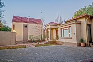 a house with a brick driveway in front of it at Crisp Guest Rooms in Bloemfontein