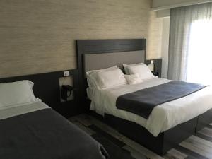a hotel room with two beds and a window at Residenza RoMa in Tropea