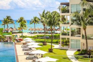 una imagen de un complejo con piscina y océano en The Elements Oceanfront & Beachside Condo Hotel, en Playa del Carmen