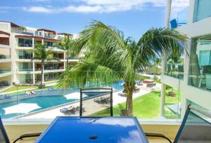 a laptop computer sitting on a table with a view of a pool at The Elements Oceanfront & Beachside Condo Hotel in Playa del Carmen