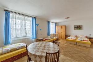 Cette chambre comprend une table, 2 lits et une fenêtre. dans l'établissement Penzion Šalamoun, à Jevišovice