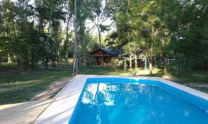 una piscina con una casa en el fondo en Quimey Lemú en San Rafael