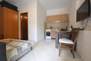 a bedroom with a bed and a table and a kitchen at Apartments Dionis in Kotor
