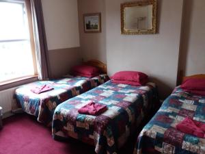 a room with two beds and a window at The Crouch Oak in Addlestone