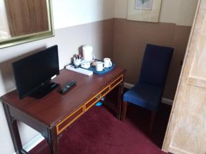 a desk with a computer and a chair in a room at The Crouch Oak in Addlestone