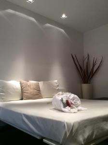 1 dormitorio con 1 cama con sábanas y almohadas blancas en 15.92 Hotel, en Cazzago di Pianiga
