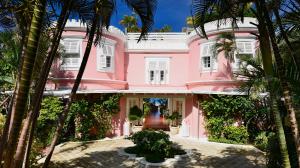 a pink house with palm trees in front of it at Cobblers Cove - Barbados in Saint Peter